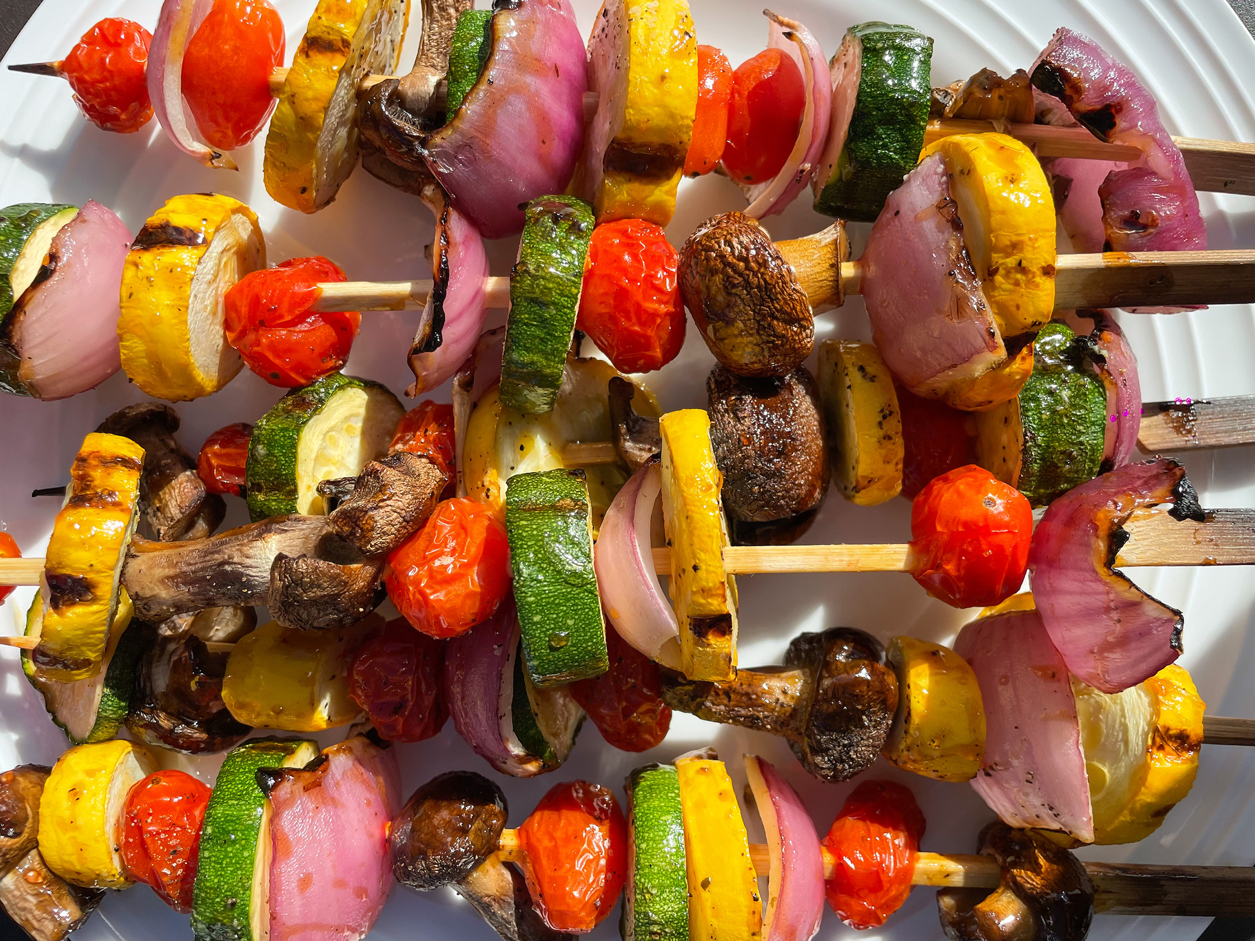 A colorful plate featuring an assortment of fresh vegetables arranged on skewers.