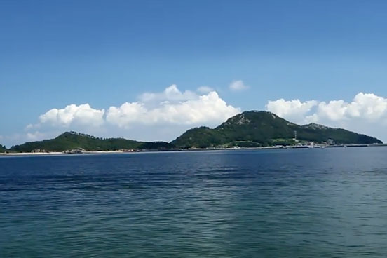 A scenic photo of a costal organic seaweed farm with rolling green hills and fluffy white clouds