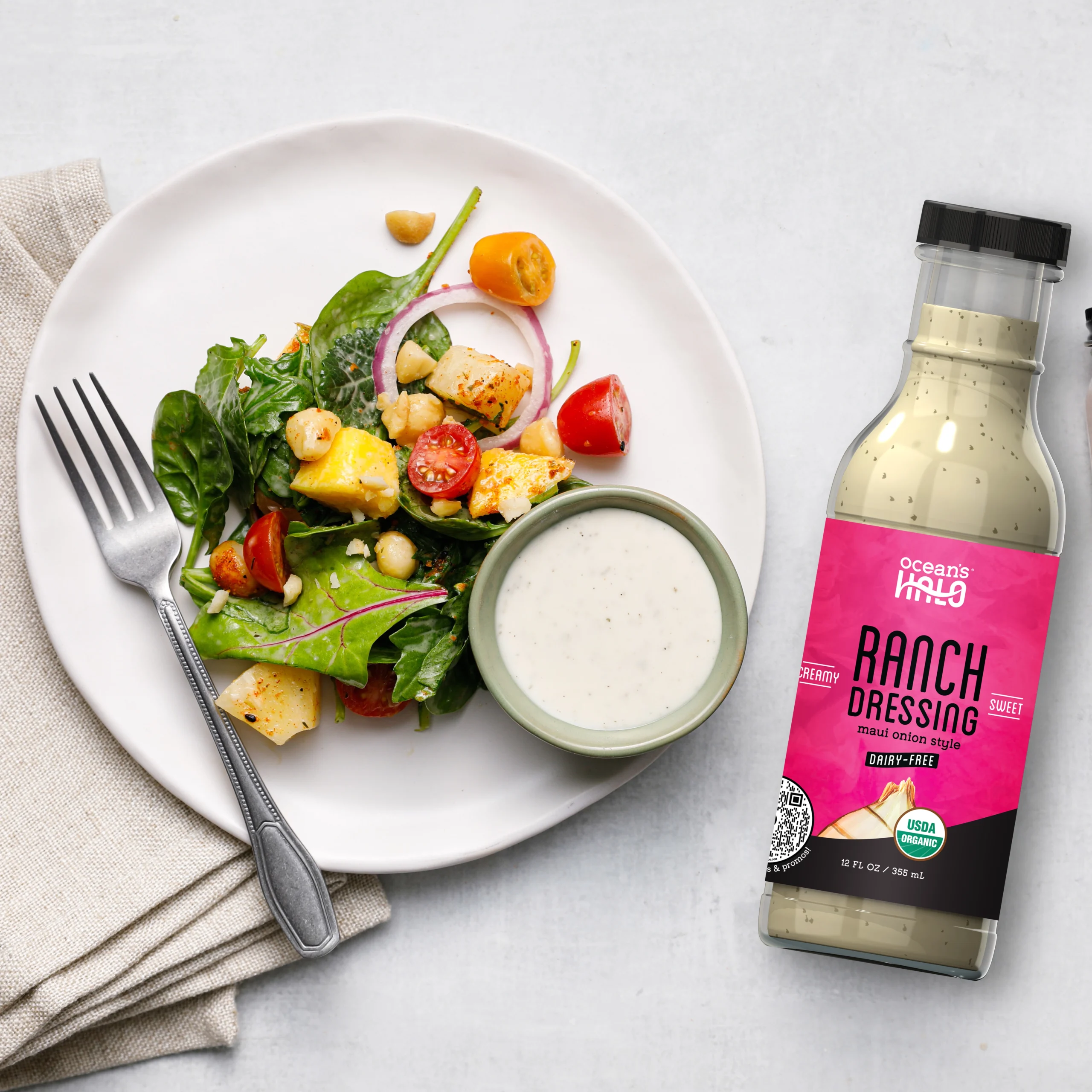 Tropical salad with pineapple, spinach, and red onion served with Ocean's Halo Dairy-Free Ranch Dressing.