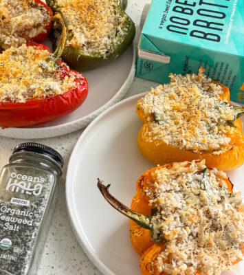 Stuffed peppers filled with cheese and topped with parmesan, beautifully arranged on a plate.