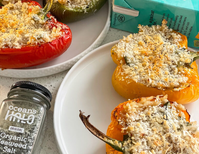 Stuffed peppers filled with cheese and topped with parmesan, beautifully arranged on a plate.