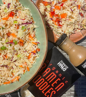 A vibrant organic pak choi salad accompanied by a bottle of sauce, showcasing fresh ingredients and flavors.