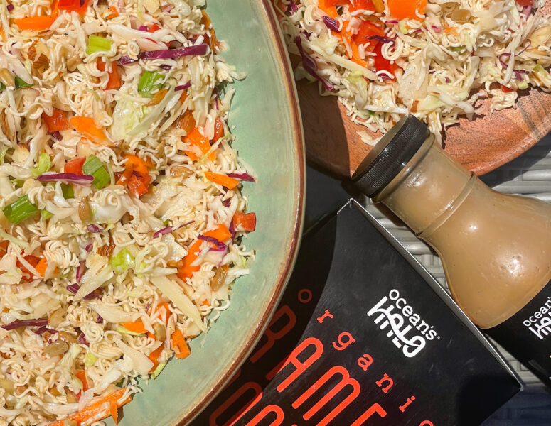 A vibrant organic pak choi salad accompanied by a bottle of sauce, showcasing fresh ingredients and flavors.