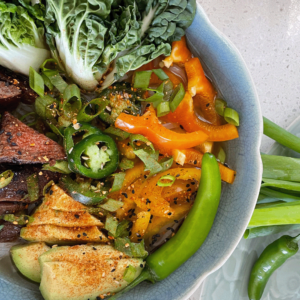 A bowl filled with colorful vegetables and tender pieces of meat, showcasing a nutritious meal.