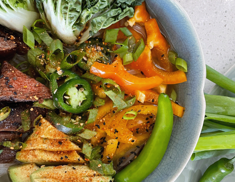 A bowl filled with colorful vegetables and tender pieces of meat, showcasing a nutritious meal.