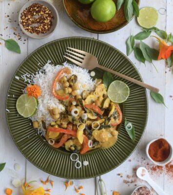 A plate filled with rice and colorful vegetables, accompanied by a fork resting beside it.