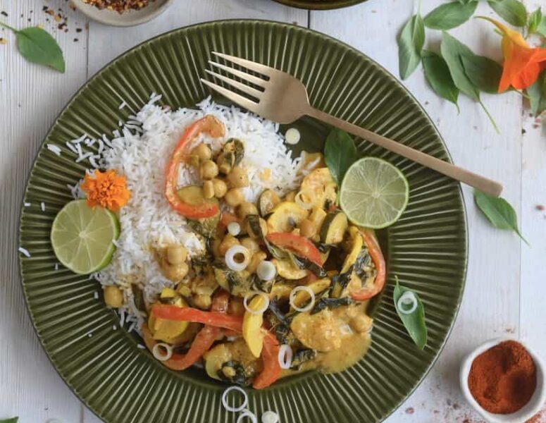 A plate filled with rice and colorful vegetables, accompanied by a fork resting beside it.