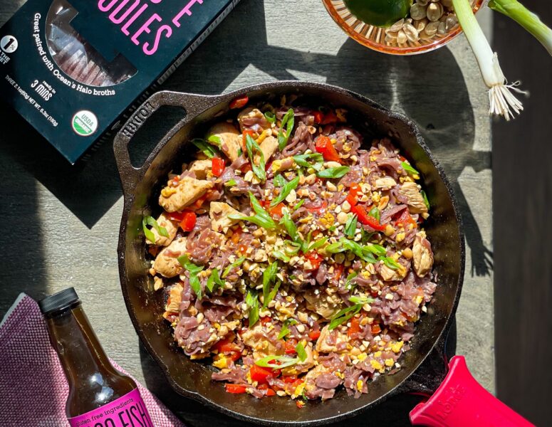 A skillet filled with sizzling meat and colorful vegetables, ready to be served.