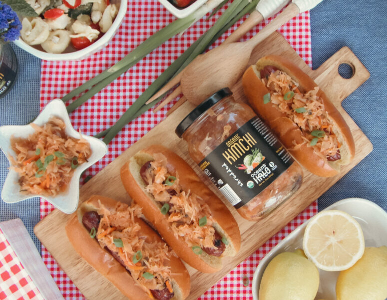 A table set with hot dogs, fresh salad, and various other delicious food items ready for a gathering.