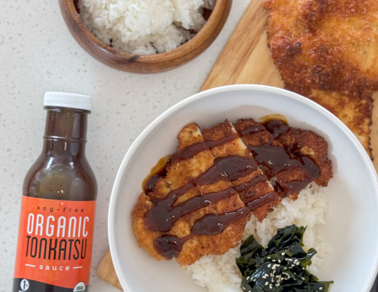 A bowl of Chicken Katsu over rice with Ocean’s Halo Organic Tonkatsu Sauce next to it