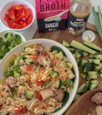 A bowl of Thai Coconut Orzo with Ginger Sesame Chicken with Thai Coconut Broth and Ginger Sesame dressing next to it