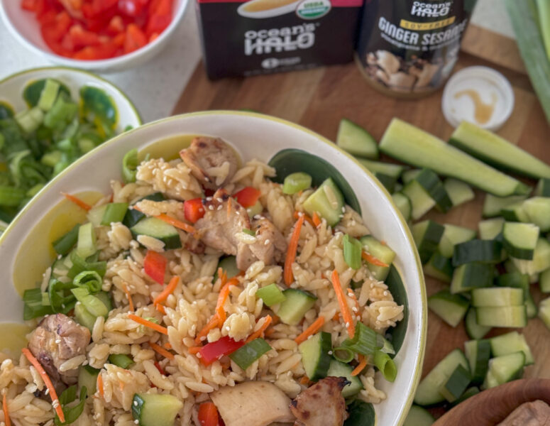 A bowl of Thai Coconut Orzo with Ginger Sesame Chicken with Thai Coconut Broth and Ginger Sesame dressing next to it