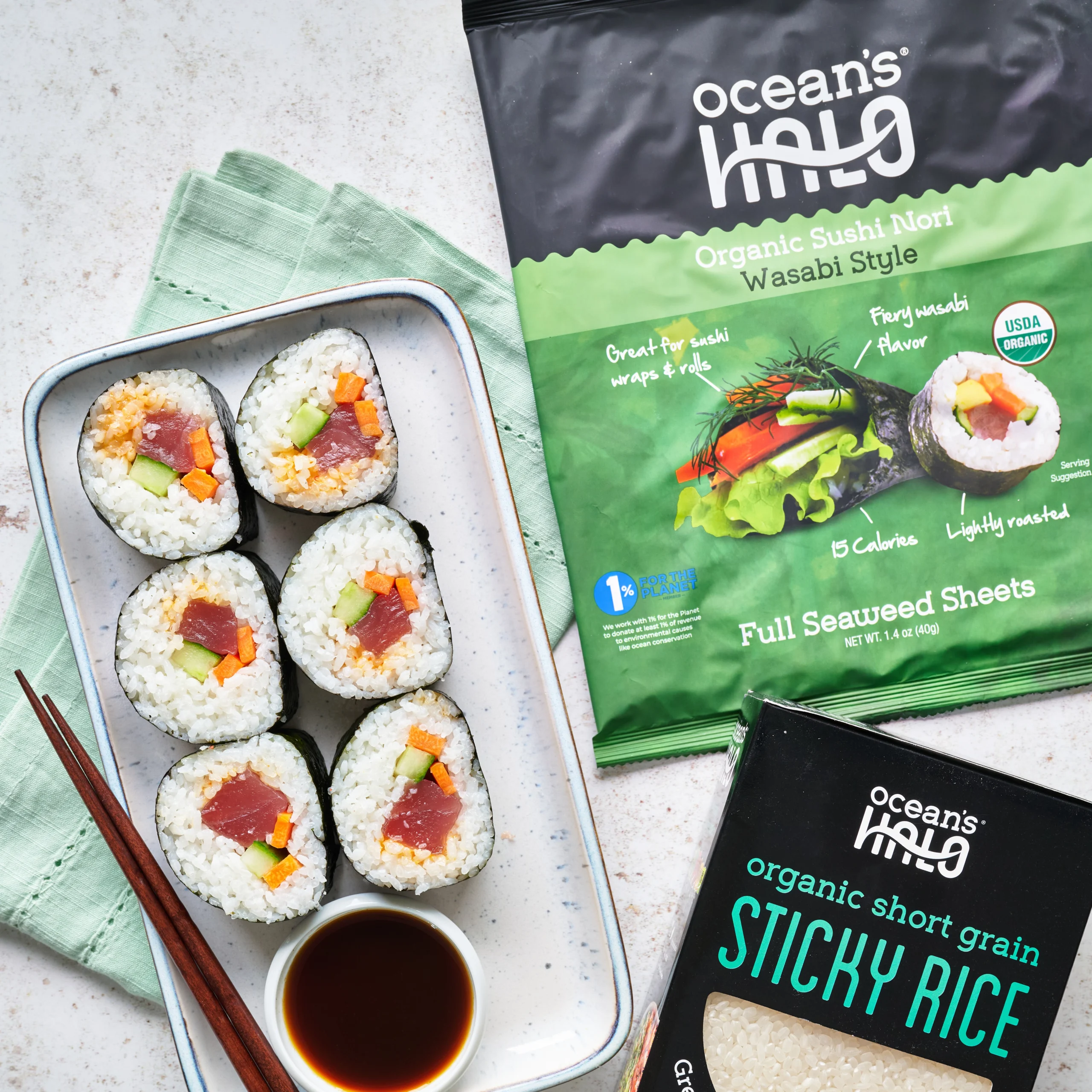 Fresh tuna sushi rolls served with NoSoy sauce alongside Ocean's Halo Wasabi Sushi Nori and Sticky Rice packaging