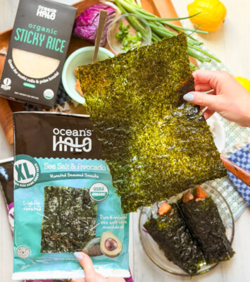Someone holding a sheet of ocean's halo sea salt and avocado oil XL seaweed snack