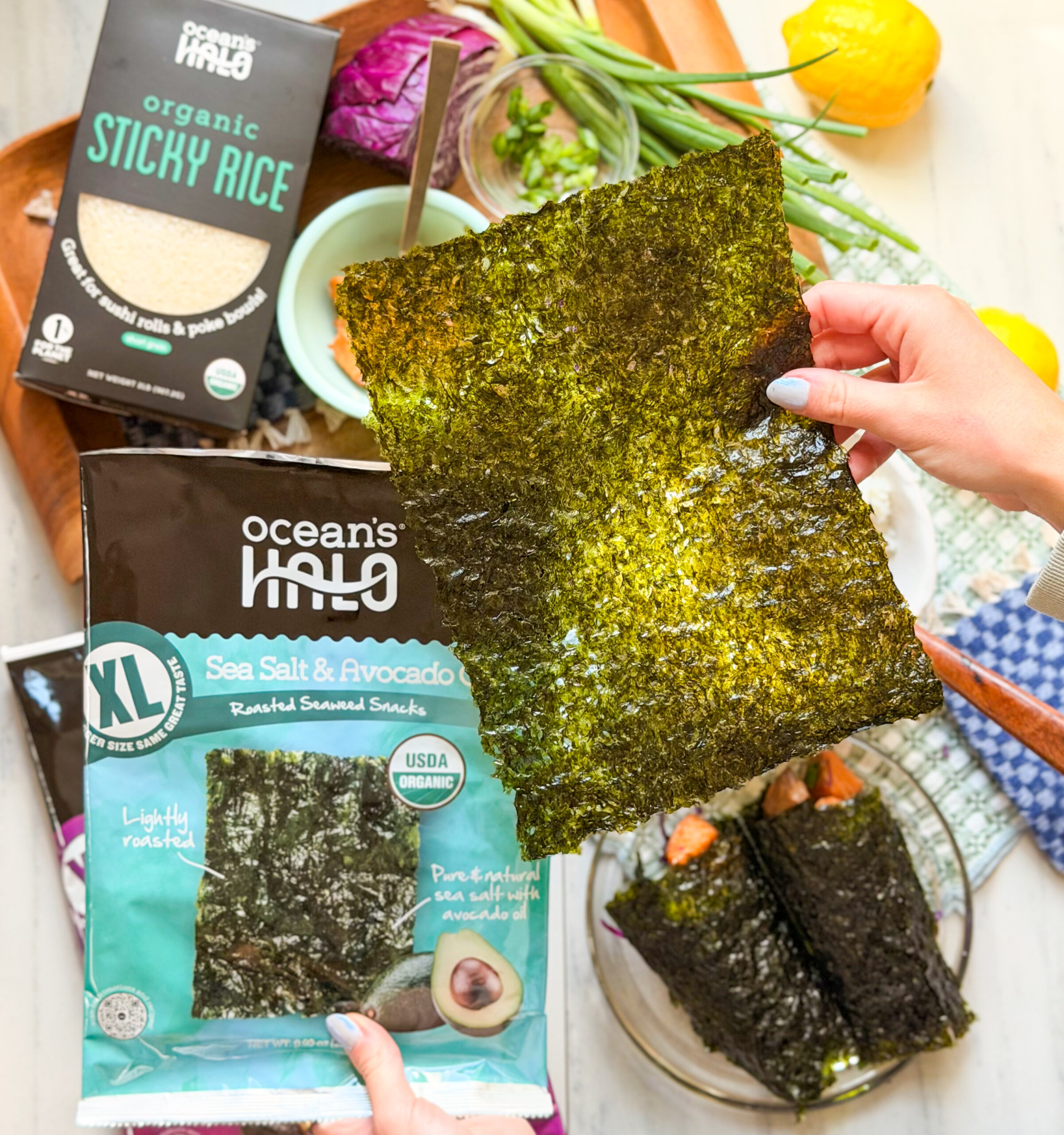 Someone holding a sheet of ocean's halo sea salt and avocado oil XL seaweed snack